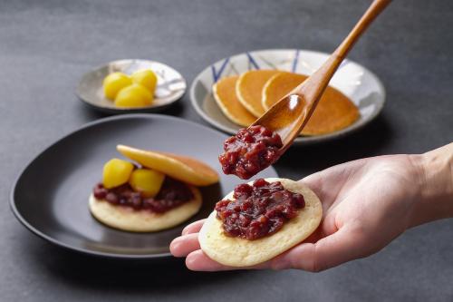 a person holding a spoon with food on a table at ORIENTAL HOTEL KYOTO ROKUJO in Kyoto