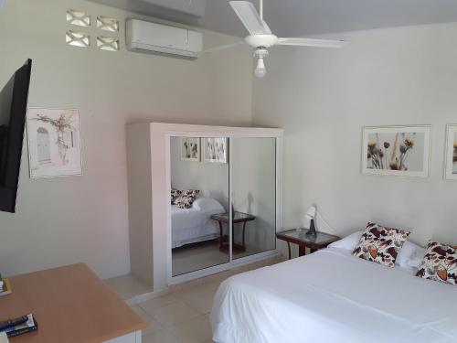 a white bedroom with a bed and a mirror at CASITA HOGAREÑA JARABACOA (independent entrance) in Jarabacoa