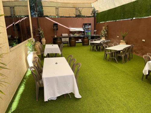 a restaurant with tables and chairs and green grass at Mizirawi Historic Hotel in Ramallah