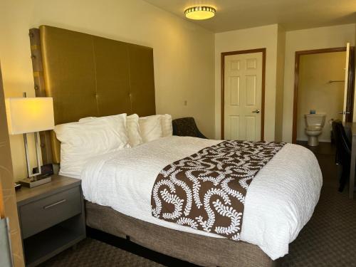 a bedroom with a large bed with a brown and white comforter at Sunrise Inn in Anacortes