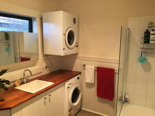 a kitchen with a washing machine and a sink at Room @ 88 in Devonport