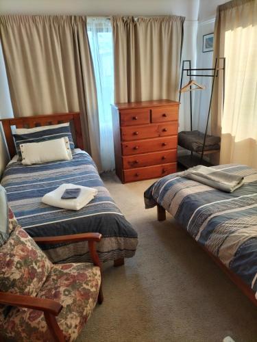 a bedroom with two beds and a dresser at Room @ 88 in Devonport