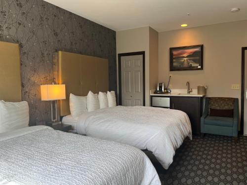 a hotel room with two beds and a desk at Sunrise Inn in Anacortes