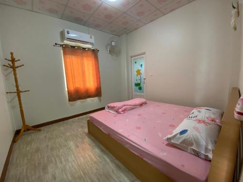 a small bedroom with a pink bed and a window at เพียงภูโฮมสเตย์ in Sattahip