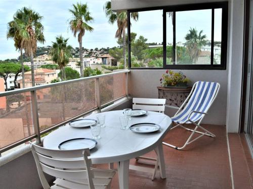 une table blanche et des chaises sur un balcon dans l'établissement Appartement 3 pièces climatisé, plage à pied, pour 4 personnes à Cavalaire - FR-1-226B-113, à Cavalaire-sur-Mer