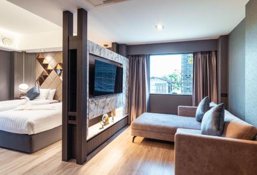 Habitación de hotel con cama y sofá en The One Smart Living en Bangkok