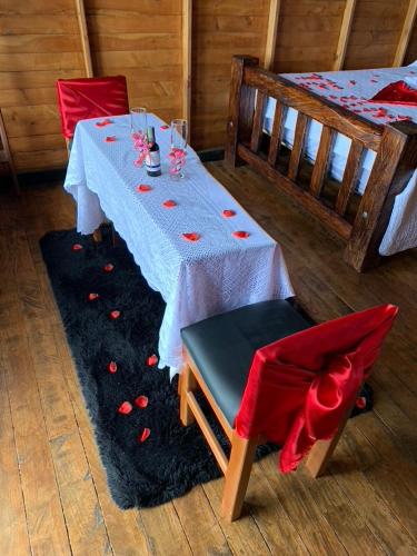 a table with two beds and red chairs in a room at Glamping la Kumbre - Gama in Gama