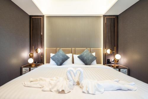 a bedroom with a bed with two towels on it at The One Smart Living in Bangkok