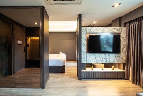 a hotel room with a bed and a television at The One Smart Living in Bangkok