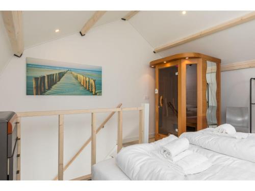 BiggekerkeにあるHoliday Home in Biggekerke with Infrared Saunaの桟橋の絵画が飾られた部屋のベッド2台