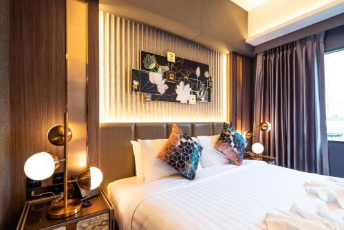 a hotel room with a bed and a window at The One Smart Living in Bangkok