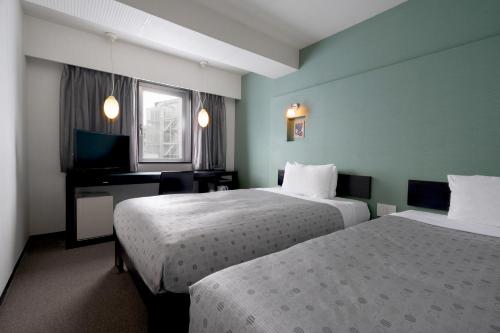 Hotel Vista Atsugi tesisinde bir odada yatak veya yataklar