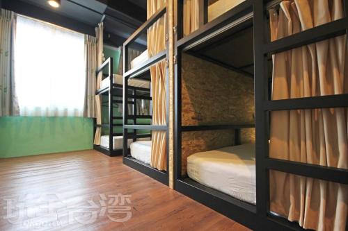 two bunk beds in a room with a window at Tourist Bunny Hostel in Tamsui