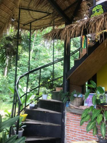 a staircase in a house with a straw roof at Hippy Hut Koh Chang in Ko Chang