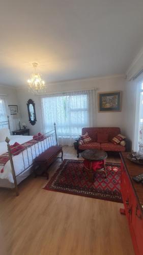 a living room with a bed and a couch at Belle Vue Guesthouse in Hermanus