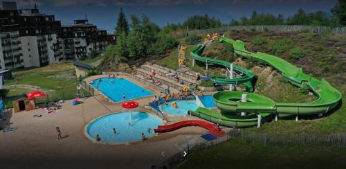 un parc aquatique avec deux piscines et un toboggan dans l'établissement Mon petit studio montagnard!, à Les Adrets