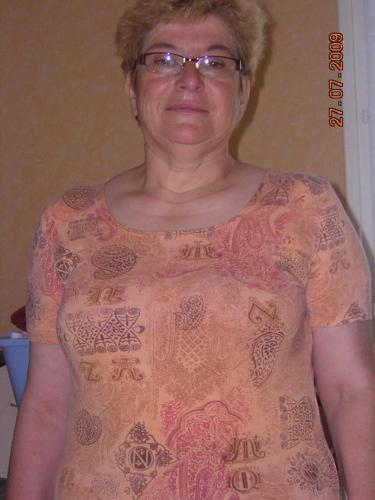 Una mujer mayor con una camisa con corazones. en villa des clématites, en Dainville