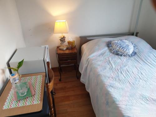 1 dormitorio con 1 cama y 1 mesa con lámpara en villa des clématites, en Dainville