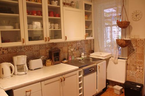 a kitchen with white cabinets and a sink at Lovely Nest near Budapest in Dunakeszi