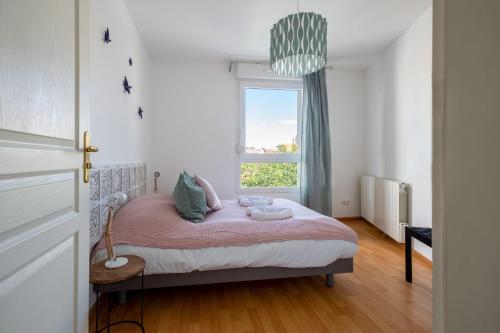 - une petite chambre avec un lit rose et une fenêtre dans l'établissement Travel Homes - The Nils, Cosy & cute with Parking, à Colmar