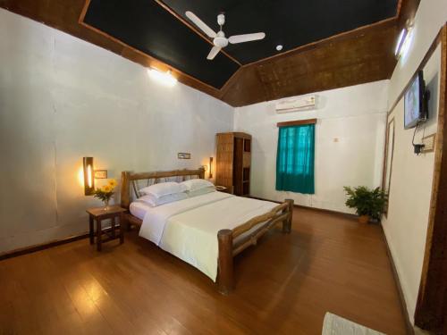 um quarto com uma cama e uma ventoinha de tecto em Wild Orchid em Ilha Havelock