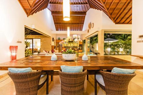 a dining room with a large wooden table and chairs at Villa Karang Berawa in Canggu