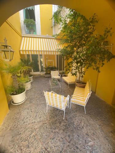 an outdoor patio with yellow chairs and a building at Palazzo Cherubini - Wellness e Spa in Rossano