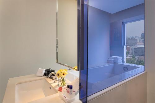 a bathroom with a sink and a mirror at Mode Sathorn Hotel - SHA Extra Plus in Bangkok