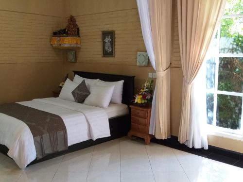 a bedroom with a bed and a window at Bali Culture Guesthouse in Ubud
