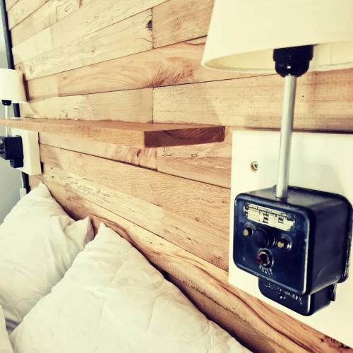 a bedroom with a wooden wall with a clock on it at Le monde d'Echozellia in Saint-Germain-des-Champs