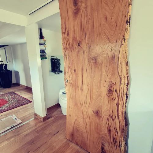 a wooden door in a room with a toilet at Le monde d'Echozellia in Saint-Germain-des-Champs