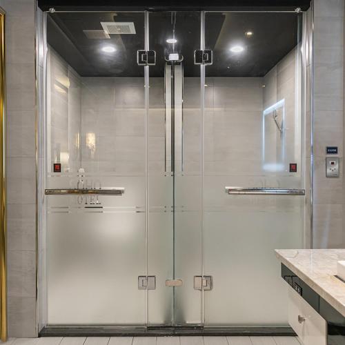 a shower with a glass door in a bathroom at Soho Motel in Taoyuan