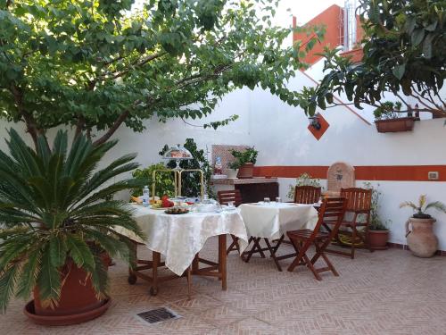 a dining room with a table and chairs and trees at B&B Historia Magistra in SantʼAntìoco