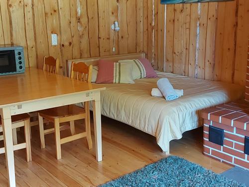 a bedroom with a bed and a table and a desk at Vanasauna Guesthouse in Valma