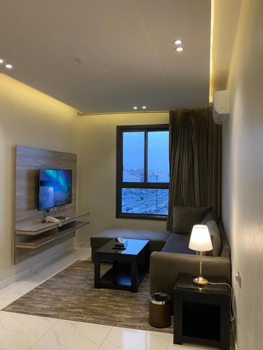 a living room with a couch and a tv at فخامة المشارف للشقق المخدومة in Abha