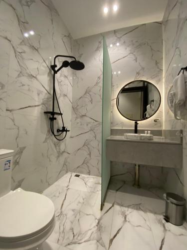 a bathroom with a toilet and a mirror at فخامة المشارف للشقق المخدومة in Abha