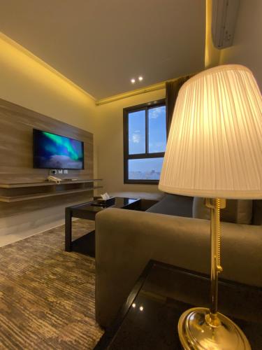 a living room with a couch and a table and a lamp at فخامة المشارف للشقق المخدومة in Abha