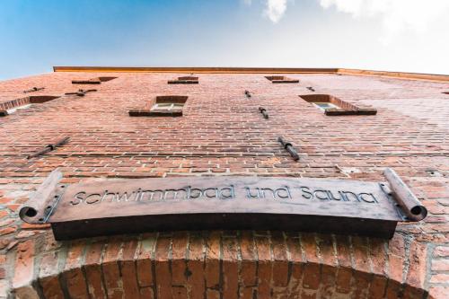 a sign on the side of a brick building at Romantik Hotel Reichshof in Norden