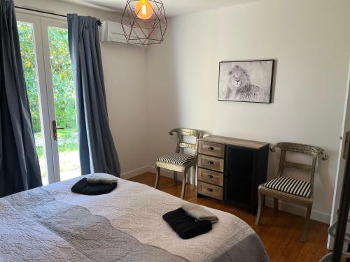 1 dormitorio con 1 cama, 2 sillas y vestidor en Villa Le grand Renard, en Saint-Antoine-Cumond