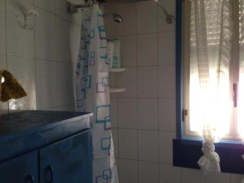 a bathroom with a shower curtain and a window at natura e relax sul mare in Gela