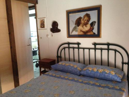 a bedroom with a bed with a picture on the wall at natura e relax sul mare in Gela