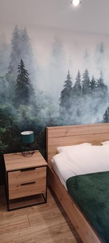 Un dormitorio con una cama y un cuadro de árboles. en Wierzchy 34, en Wierzchy