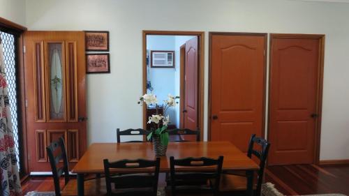 a dining room table with a vase of flowers on it at Arcadia Gardens in Arcadia