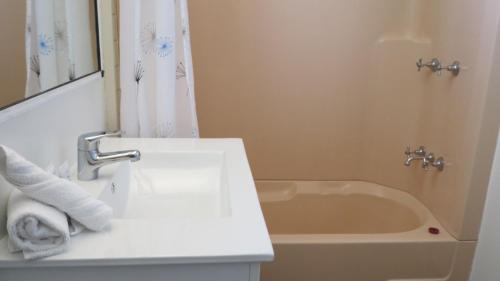 a bathroom with a sink and a bath tub at Picnic Bay Chalet Unit 2 in Picnic Bay