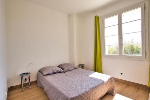 ein Schlafzimmer mit einem Bett und einem Fenster in der Unterkunft Le Belvédère du Vieux Port Plages centre et gare à pied in Saint-Raphaël