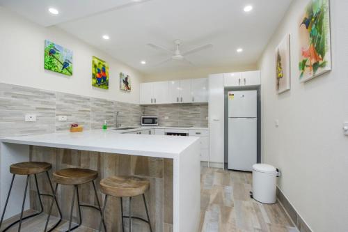 a kitchen with a white counter and stools at Island View Unit 2 in Arcadia