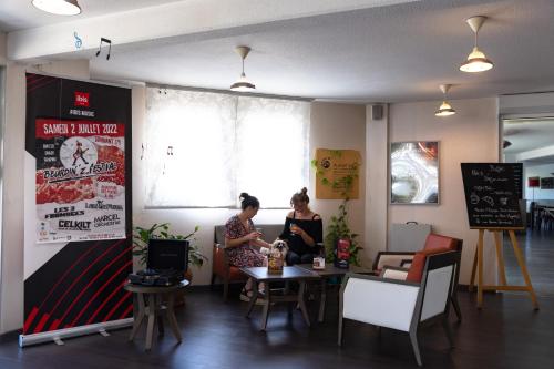 two women sitting at a table in a restaurant at Hotel ibis Autun in Autun