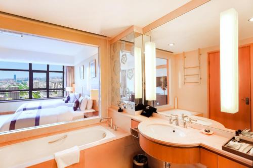 a bathroom with a tub and a large window at Kunshan Yu Yuan Garden Hotel in Kunshan