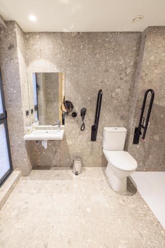 a bathroom with a toilet and a sink at Inn Boutique León in León