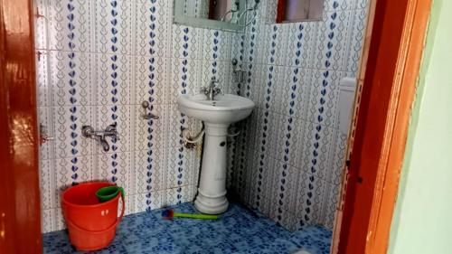 a bathroom with a sink and a bucket at Queen Palace guest house in Srinagar